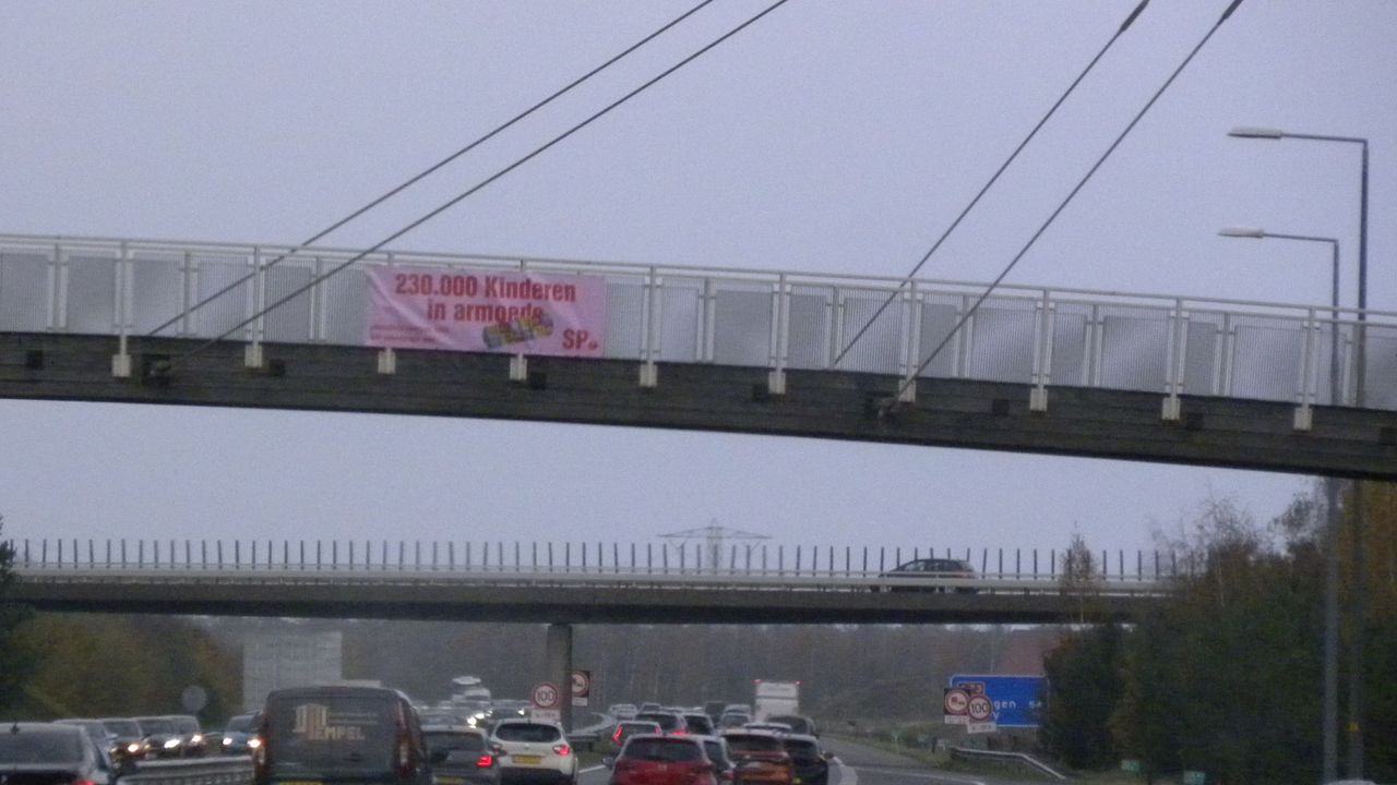 SP hangt banner op boven A73 om aandacht te vragen voor aantal kinderen in armoede
